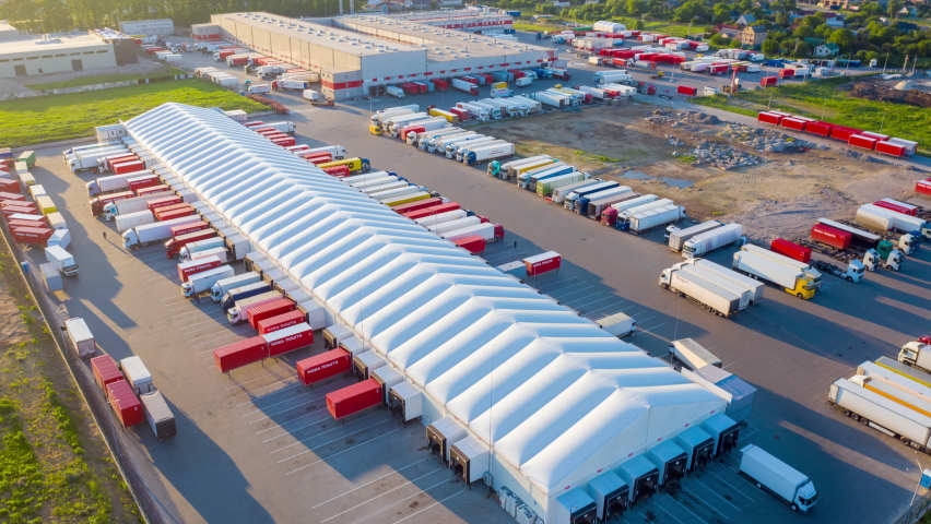 Aerial hyper lapse (hyperlapse - motion time lapse) of a logistics park with a loading hub. Semi-trailer trucks stand at warehouse ramps for load and unload goods Royalty-Free Stock Footage #1074202952