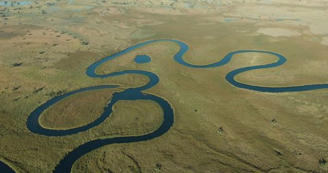 Spectacular aerial fly over view of the beautiful scenic curving patterened waterways and lagoons of the Okavango Delta Botswana