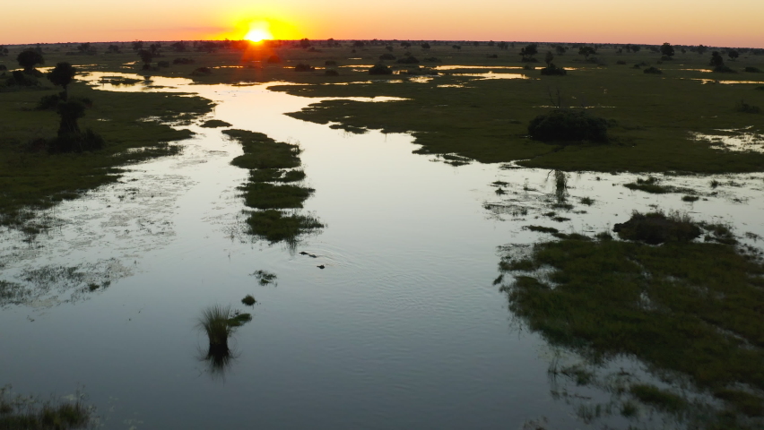 Spectacular aerial fly over view of the beautiful scenic waterways and lagoons of the Okavango Delta at sunset Royalty-Free Stock Footage #1074203711