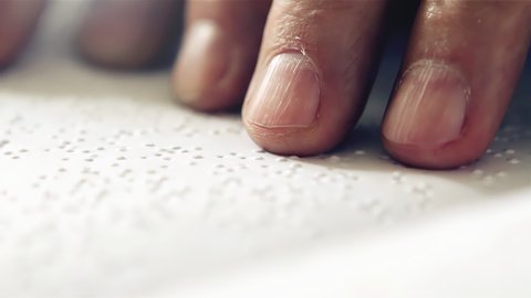 Hands of a Blind Man reading Braille. Close Up. 4K Resolution.