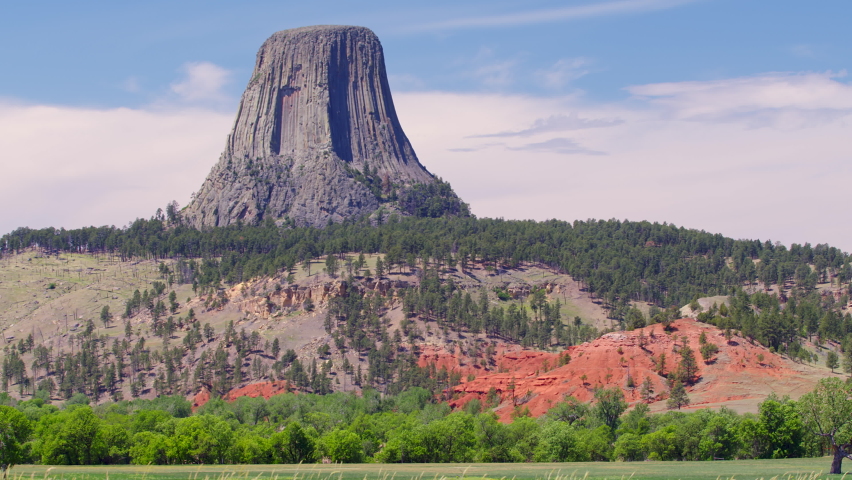 Timelapse of clouds moving through the sky at Devils Tower in Wyoming viewing the colorful landscape below.