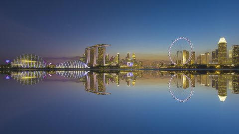 Beautiful Time lapse of Night to Day of Singapore skyline with reflection. Sunrise. Prores. Pan up motion timelapse. 4K available.