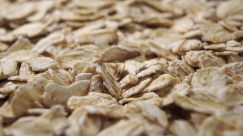 Uncooked oatmeal flakes texture close up. Macro shot. Rotation