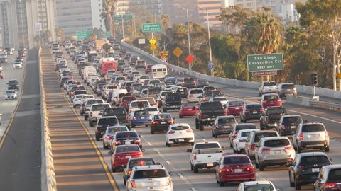 SAN DIEGO, CALIFORNIA USA - 15 JAN 2020: Busy intercity freeway, traffic jam on highway during rush hour. Urban skyline and highrise skyscrapers. Transportation concept and transport in metropolis.