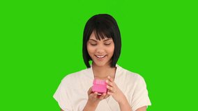 Asian woman opening a gift against a green screen