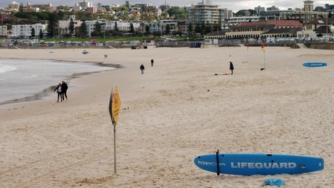 SYDNEY, NSW, AUSTRALIA, JUNE 11 2021. Slow motion visitors and Lifeguard surfboard at Bondi beach.