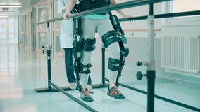 A patient in exoskeleton is being assisted by a doctor while walking - Powered by Shutterstock - Get 15% off with code: PIKWIZARD15