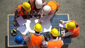Group of Solar power plant Engineers Team Meeting and discussion to brainstorming with blueprint on solar cell top table Planning for a New Project of Environmental Power at construction site outdoors - Powered by Shutterstock - Get 15% off with code: PIKWIZARD15