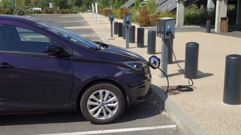 Bordeaux, France - May 2021 : Renault Zoe electric car plugged and charging at a charging station