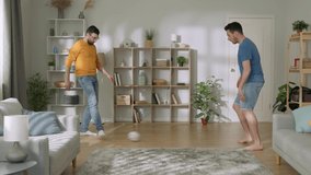 Young men playing football. Funny man dribbling the ball, enjoying his time together with bro - happy family, recreational pursuit concept 4k footage