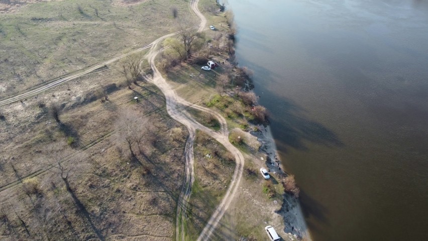 Flying along the banks of the Desna river in spring over vacationers