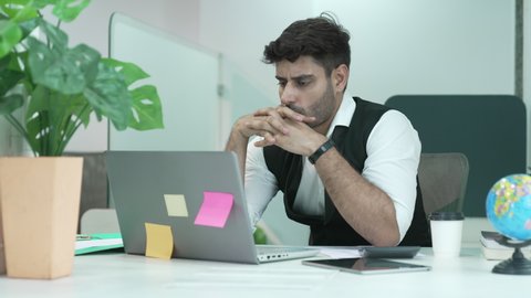 Portrait of Indian man and serious millennial hard working at office,thinking and feeling thoughtful.Working from Home concept.business situation,startup in Loft office concept.lifestyle concept.

