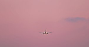 Cinematic slow motion front view white airplane on pink sunset sky background. 4K travel background for tourism business. Straight shot of jet cockpit with turned on landing lights. Airport footage - Powered by Shutterstock - Get 15% off with code: PIKWIZARD15