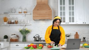 Smiling woman housewife in home kitchen slices cucumber listen teacher chef, study watch online culinary cooking course lesson, distance education video conference call webcam chat laptop computer
