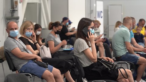 Kyiv, Ukraine - June 13, 2021. Many people in surgical masks sit in a mass vaccination point, waiting their turn for vaccination. Place to wait, turn.