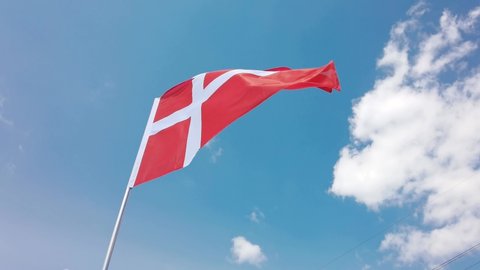 Denmark. National country flag on blue sky background. Flying fabric symbol. Tourism or travel summer day. international patriotic emblem. Nobody. Horizontal video