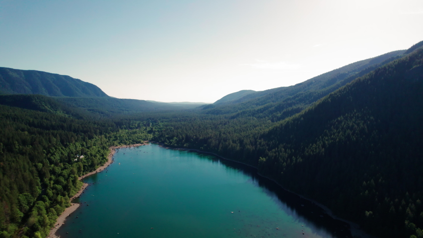 Beautiful Washington Nature Aerial with Turquoise Color Mountain Lake Surrounded by Trees. Amazing drone view of scenic Rattlesnake Lake in dense forest