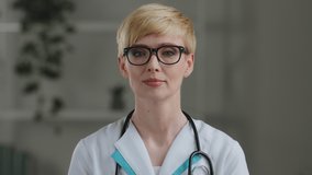 Portrait caucasian mature 40s woman doctor female surgeon medical worker nurse practitioner with short hair wears stethoscope around neck speaks consultations remotely online during pandemic lockdown