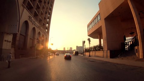 Cairo, Egypt - 11 September, 2019: Car traffic and pedestrians in the streets of central Cairo, driving POV at sunset