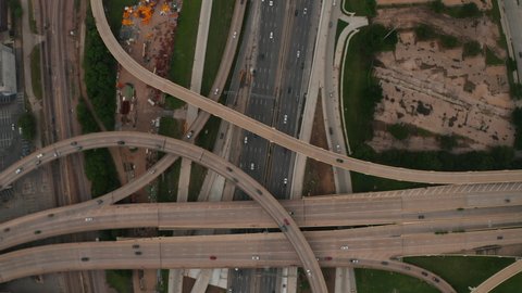 Aerial birds eye overhead top down panning view of large and complex multilane highway intersection. Cars smoothly driving in lanes. Dallas, Texas, US
