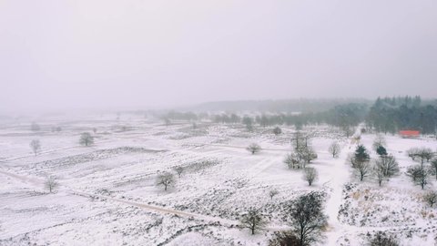 Aerial Over Snow Covered winter Landscape Fields At Veluwe National Park. Follow Shot