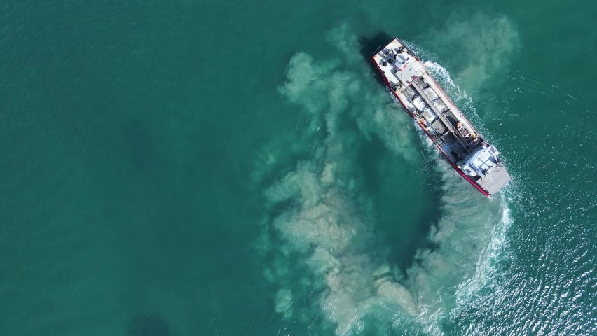 Unique high view of the environmental impact to a sensitive marine precinct cause by a large industrial ship maneuvering. Royalty-Free Stock Footage #1074285596