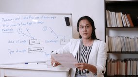 4K Asian woman teacher or tutor teaching online at home. Covid-19 new normal lifestyle during coronavirus lockdown quarantine. Online remote study