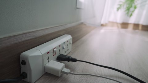 man is unplugging his appliances after not use to save electricity and reduce costs. Electrical appliances if not unplug will have a circulating current causing a charge. concept of save.