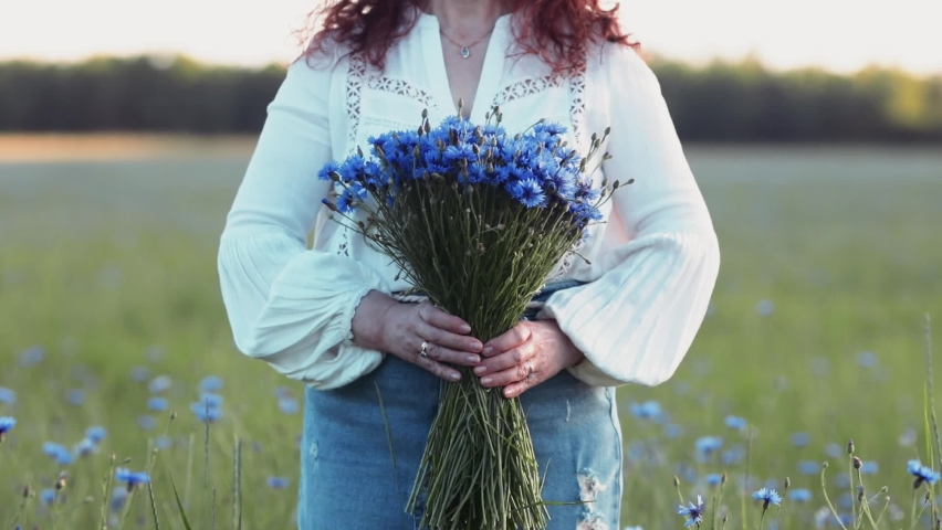 beautiful woman gives a bouquet of blue cornflowers Royalty-Free Stock Footage #1074299531