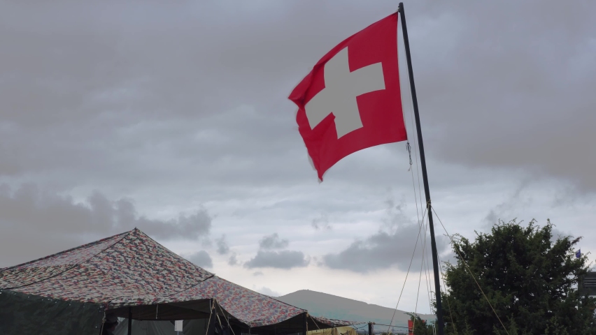 Aid station, field hospital. Surgical care to the wounded in the war. Red cross flag in the wind on mobile medical camp