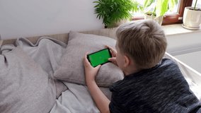 4K Boy Playing Mobile Game on Smartphone Holding Smartphone with Green Screen
