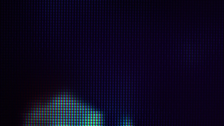 Macro view of a television LED screen at the time of broadcasting a TV program. Colored pixels create an abstract pattern when viewed up close. Royalty-Free Stock Footage #1074312365
