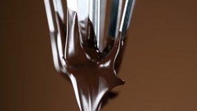 Super slow motion of mixing melted liquid premium dark chocolate with a whisk.
