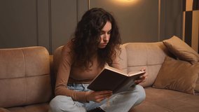Young woman reading book in cozy living room, learning, studying, education, read books, stay home concept.