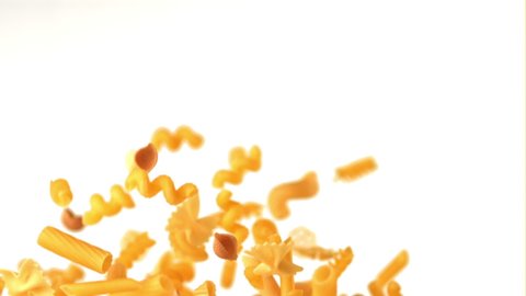 Super slow motion different kinds of dry pasta. On a white background. Filmed on a high-speed camera at 1000 fps. High quality FullHD footage