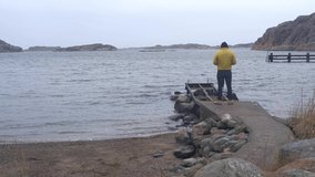 Close up of a white man on his phone at the coast of Sweden in winter