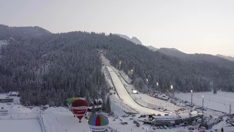 zakopane , Poland - 02 16 2021: Ski jumping ramp and hot air balloons at Zakopane in Poland. Aerial panoramic view