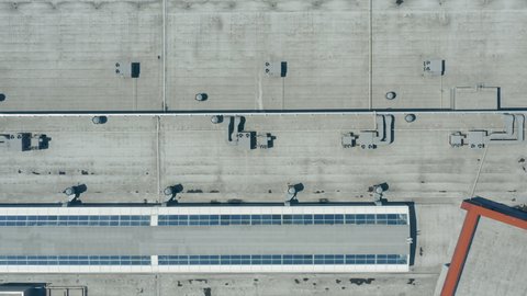 Air conditioners installed on the concrete roof of the shopping center. Panoramic overhead drone shot. The roof of the shopping center with air conditioning and ventilation system - top view shot.