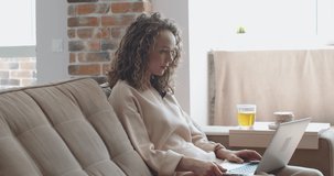 Young cheerful woman with curly hair communicates by video communication with friends. High quality 4k footage