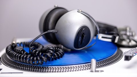 DJ turntables with changing headphones and different coloured record vinyls