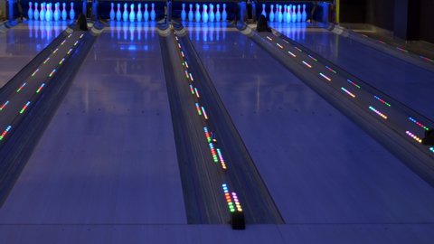 Colorful bowling alley. Bowling lane waiting for gamers. Bowling pins standing ready for game. Colorful Illumination.