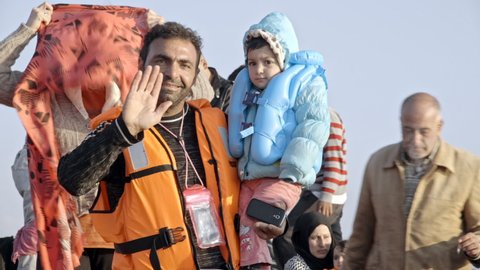 Chios , Greece - 10 27 2015: Refugee families from Syria and Iraq arriving by rubber boat on island in Greece.