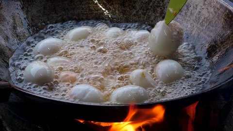 Handheld Close up shot eggs on hot boiling frying pan - deep fried duck eggs