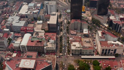 High angle aerial view of heavy traffic in streets of downtown. Drone flying forwards and camera tilting down. Mexico city, Mexico.