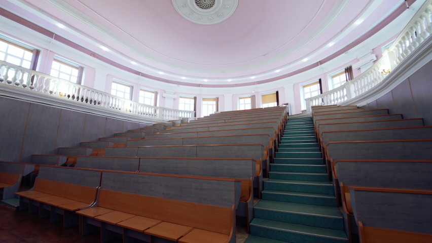 Modern auditorium for lectures. Empty conference hall at the university. Meeting room for educational purpose. Motion camera back to the door.