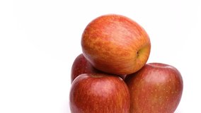 Video of a red apple turn on a white background
