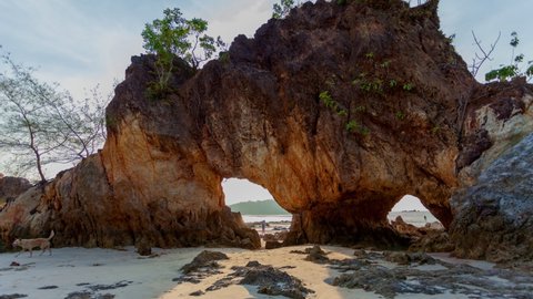 time lapse Tourists come to see the strange rock with two large holes and take selfies. sunset in the hole of rock at Hin Thalu Buffalo beach  Phayam island Ranong Thailand.4K video amazing in nature