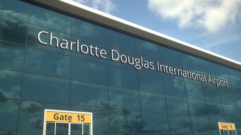 Commercial plane landing reflecting in the windows with Charlotte Douglas International Airport text