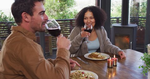 Mixed race couple toasting and drinking wine while having lunch at a restaurant. couple honeymoon and vacation concept