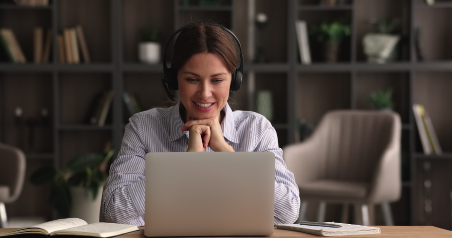 Female tutor sit at desk gives private online class remotely wear headset talking by videocall application, looks at laptop screen counsellor provide support. Negotiations use videoconference concept Royalty-Free Stock Footage #1074370889